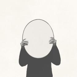 person holding up mirror facing out obscuring their face