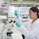 Girl in lab coat performing an experiment