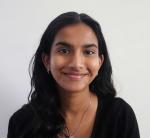 A headshot of Sruthi as she smiles widely to the camera.