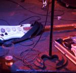 A glass of beer, white guitar and audio visual equipment on a stage