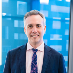 Image of man in suit in front of blue background